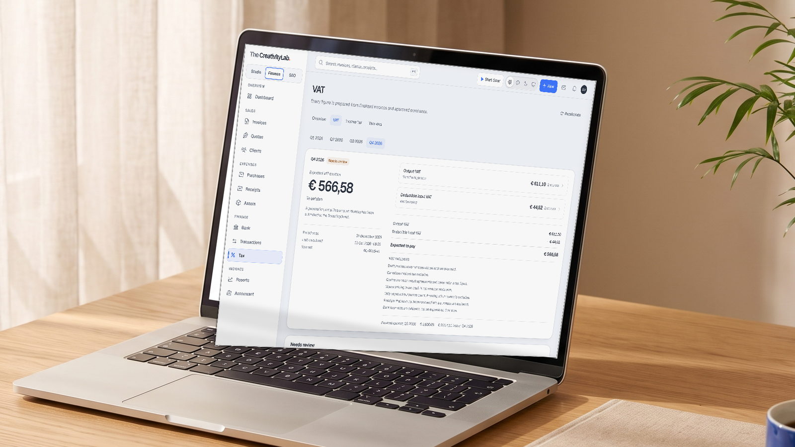 Finance OS: the VAT position for the quarter, prepared from finalised invoices and approved purchases, on a laptop at a wooden desk